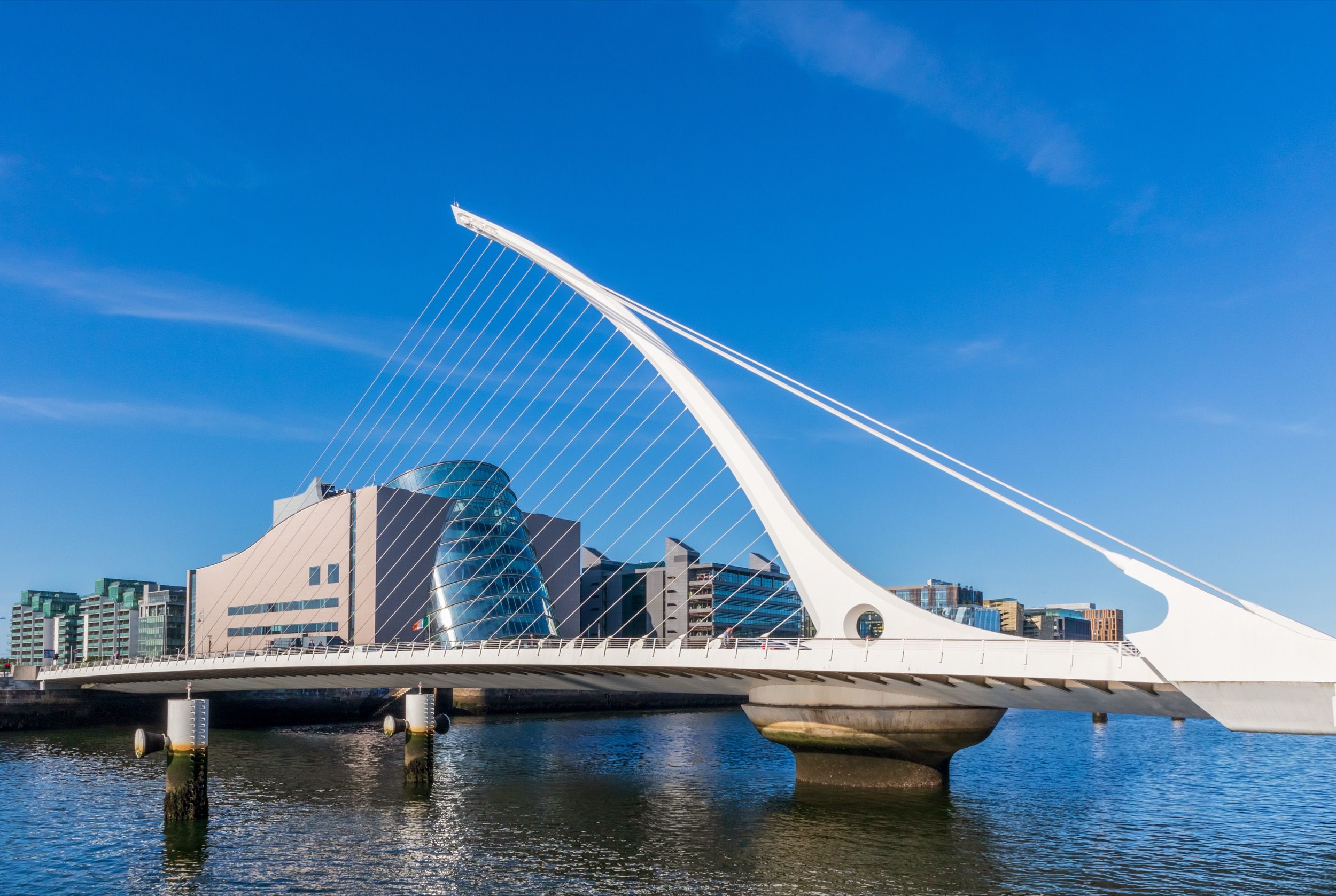 Die elegante Samuel-Beckett-Brücke mit ihrer charakteristischen weißen Harfenform überspannt den River Liffey vor der Kulisse des Convention Centre Dublin.