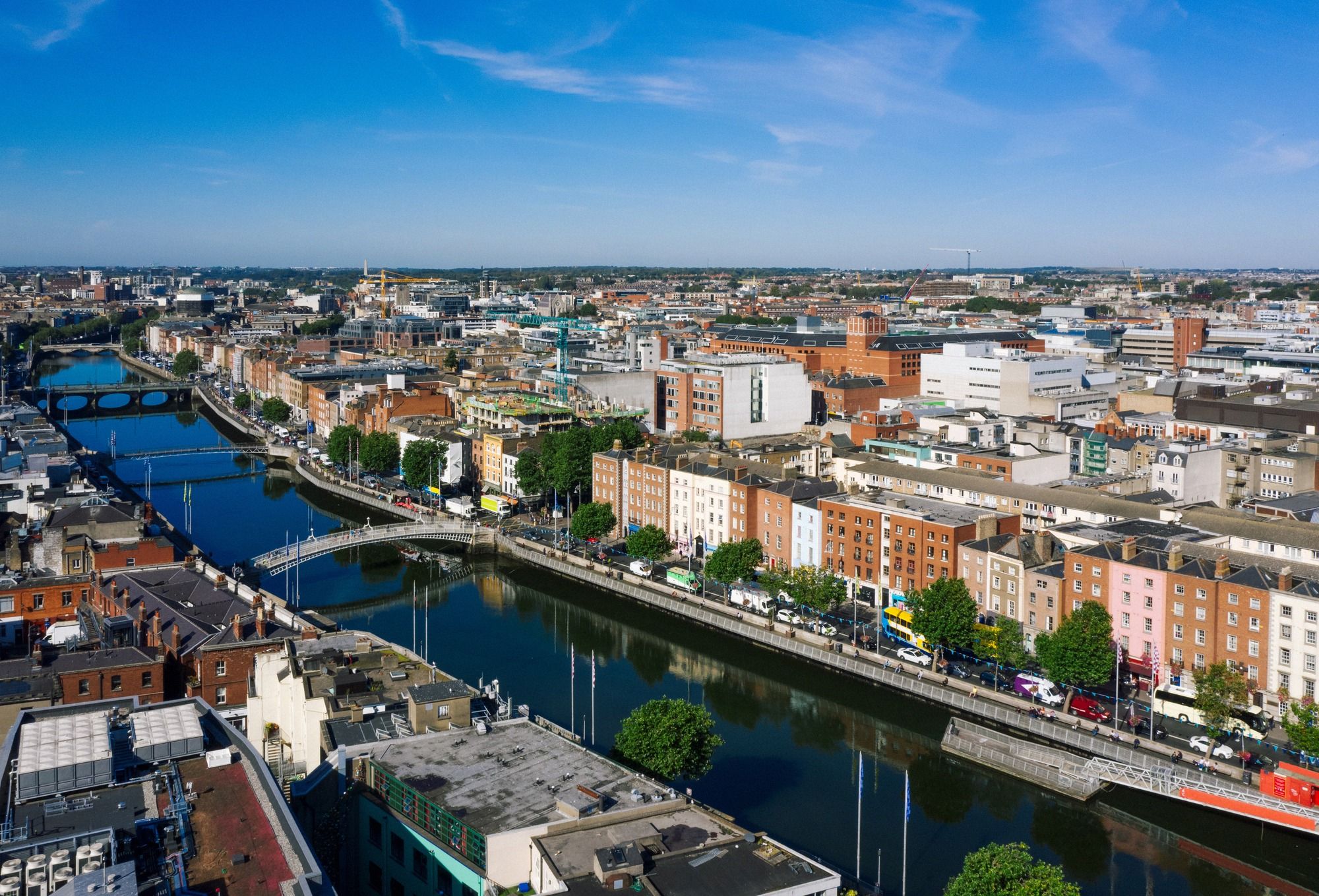 Luftaufnahme über den River Liffey mit der Ha'penny Bridge im Vordergrund und dem georgianischen Stadtpanorama Dublins.