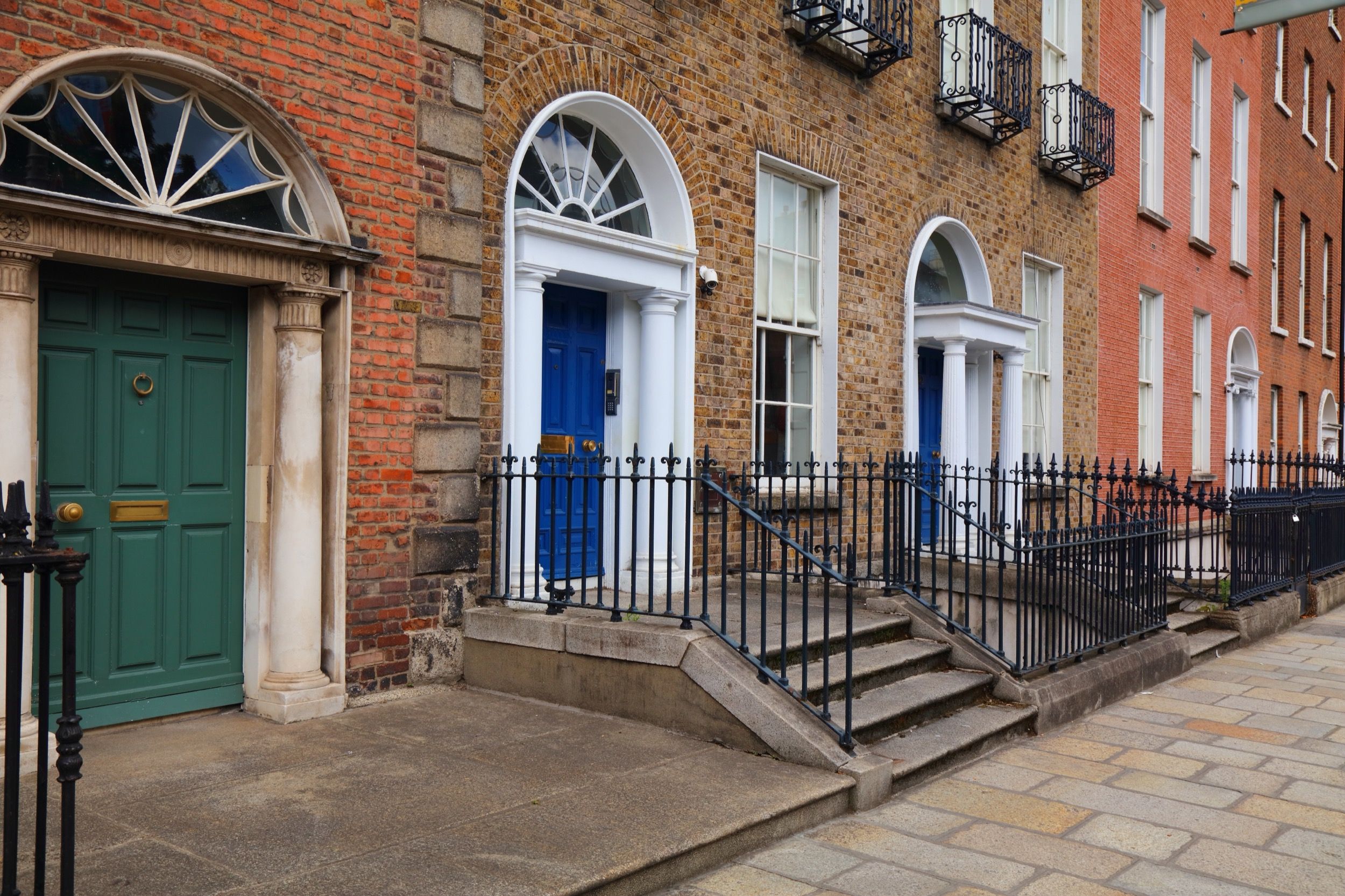 Typische georgianische Eingangstüren in Grün und Blau mit Fächerfenstern und Säulenportalen an den Backsteinfassaden rund um den Merrion Square.