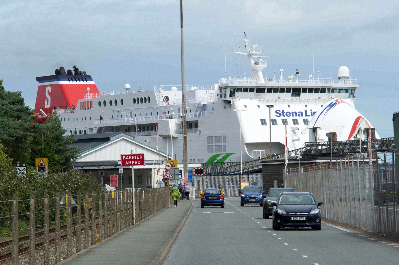Zufahrt zum Fährterminal in Holyhead in Wales, im Hintergrund eine Fähre am Anleger.